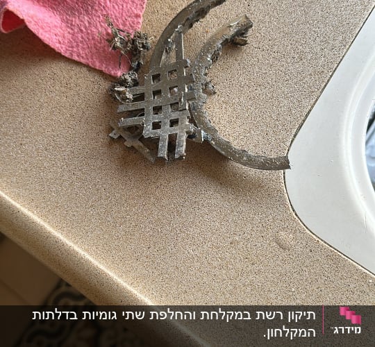 מסננת מתכת ישנה על משטח ליד כיור
